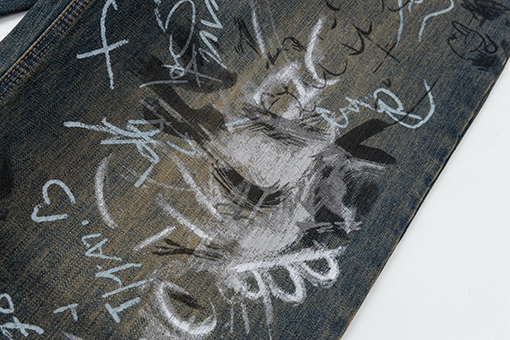 バレンシアガ 手描きのグラフィティとウォッシュをしたダメージのルーズフィットジーンズ