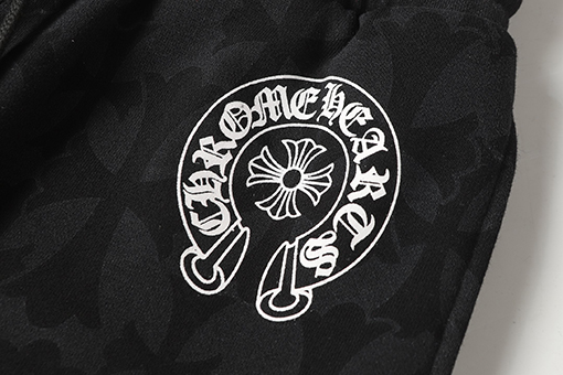 クロムハーツ ダークな模様のサンスクリット文字プリントのズボン