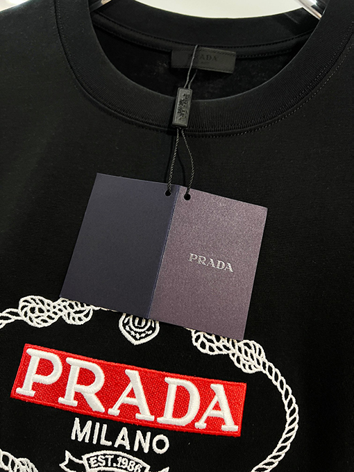 プラダ 胸に麻縄の刺繍がされた、クラシックな1986のスローガン文字ロゴ半袖Tシャツ