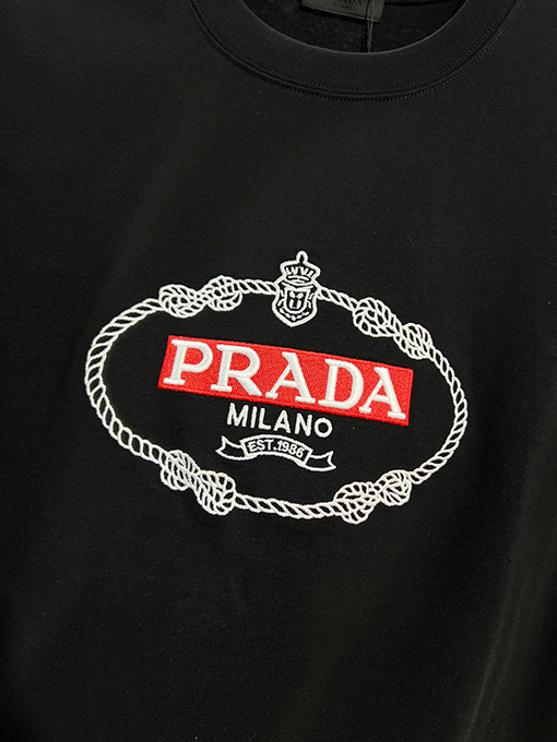 プラダ 胸に麻縄の刺繍がされた、クラシックな1986のスローガン文字ロゴ半袖Tシャツ